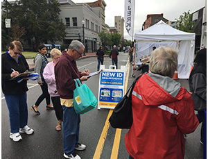 People standing in line completing a survey.