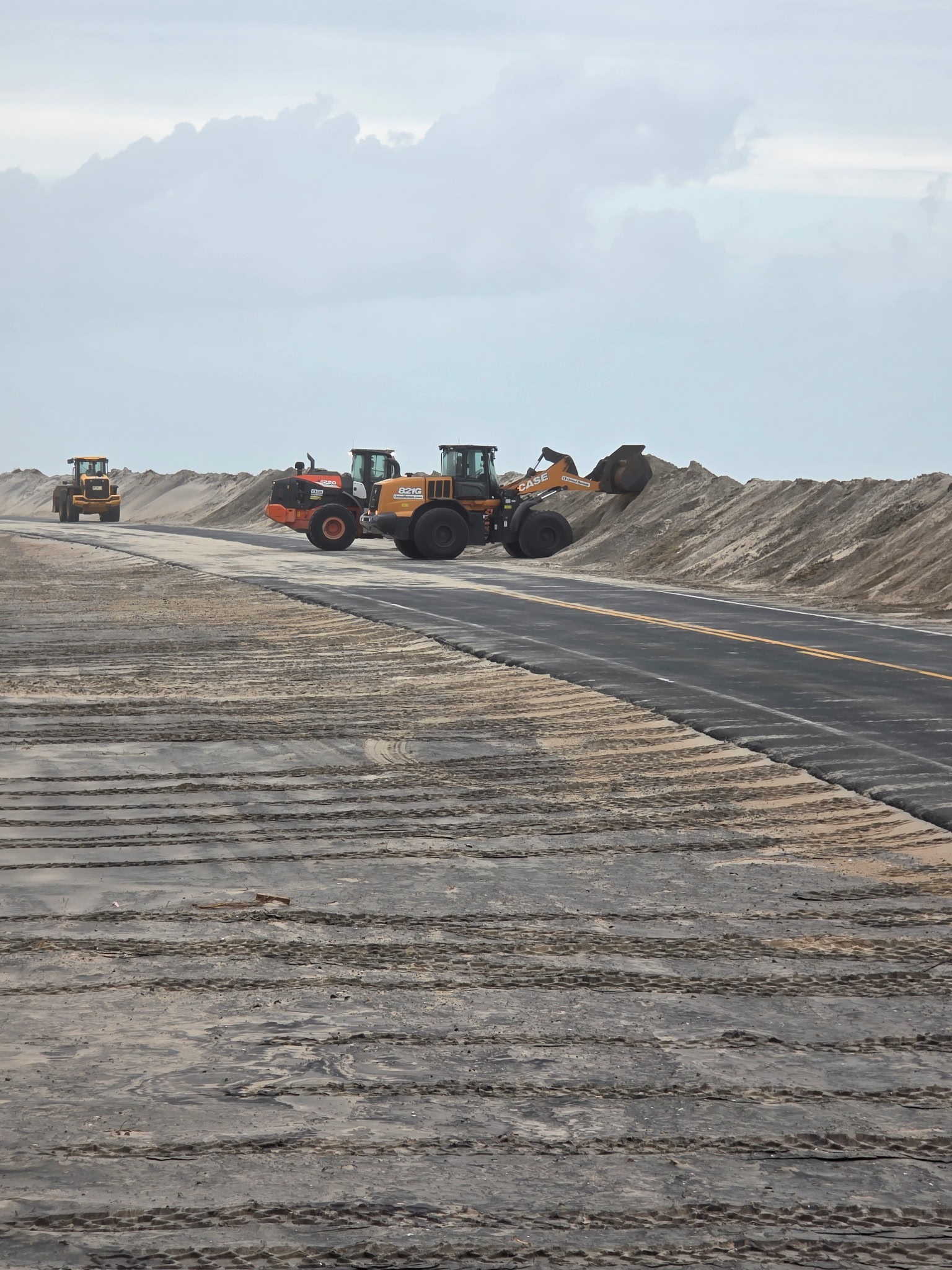 NCDOT crews worked to clear sand from the road during a storm in 2025. 
