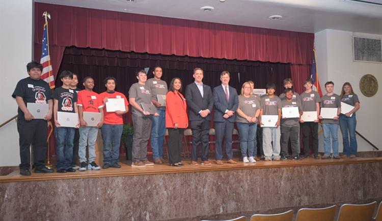 Students line up to have their picture taken with their new laptops.