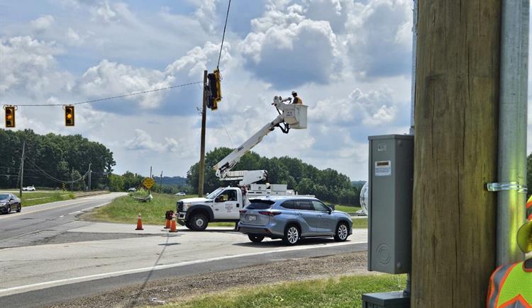 Crews adjust settings on a traffic signal