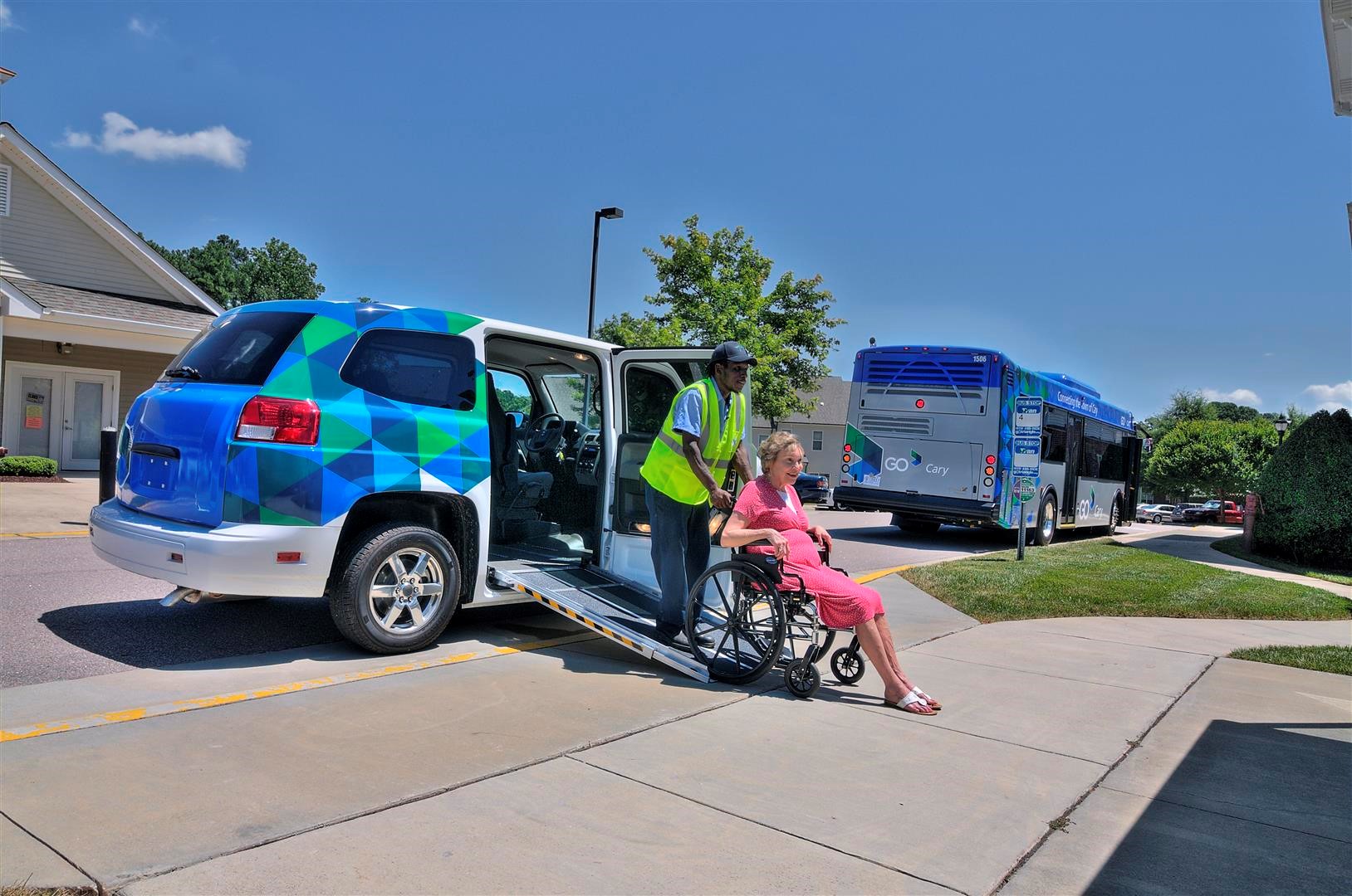 Transportation worker assisting a woman with a disibility exit her vehicle