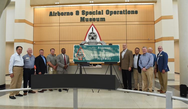Officials pose in front of new Airborne & Special Operations highway sign